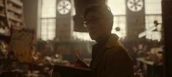 Movie still from “Loki” (2021), created by Michael Waldron – A man with glasses is writing in a notebook; Close Up shot, Low angle