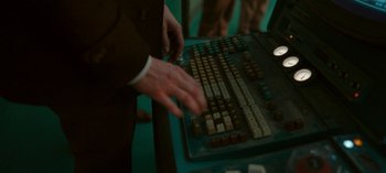 Movie still from “Loki” (2021), created by Michael Waldron – A man in a brown suit is using a computer keyboard; Extreme Close Up shot, High angle
