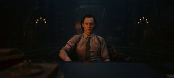 Movie still from “Loki” (2021), created by Michael Waldron – A man sitting in a chair in front of a window; Medium shot, Over the shoulder angle
