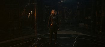 Movie still from “Loki” (2021), created by Michael Waldron – A woman standing in a dark room with candles; Wide shot, High angle