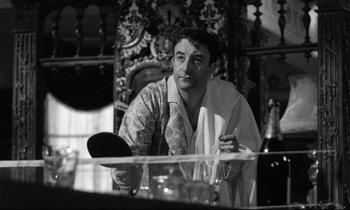 Movie still from “Lolita” (1962), directed by Stanley Kubrick – A black and white photo of a man sitting at a table; Medium shot, Low angle