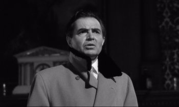 Movie still from “Lolita” (1962), directed by Stanley Kubrick – A black and white photo of a man wearing a coat and tie; Close Up shot, Low angle