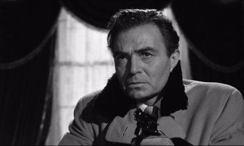 Movie still from “Lolita” (1962), directed by Stanley Kubrick – Black and white photograph of a man in a trench coat; Close Up shot, Low angle