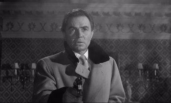 Movie still from “Lolita” (1962), directed by Stanley Kubrick – An old photo of a man holding a gun; Close Up shot, Low angle