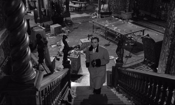 Movie still from “Lolita” (1962), directed by Stanley Kubrick – A black and white photo of a man walking down a staircase; Wide shot, High angle
