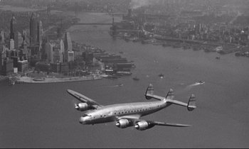 Movie still from “Lolita” (1962), directed by Stanley Kubrick – An airplane flying over a body of water; Extreme Wide shot, Overhead angle