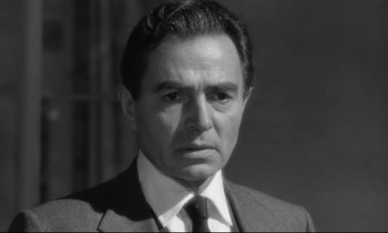 Movie still from “Lolita” (1962), directed by Stanley Kubrick – Black and white photograph of a man wearing a suit and tie; Close Up shot, Low angle