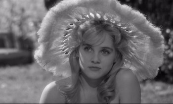 Movie still from “Lolita” (1962), directed by Stanley Kubrick – A black and white photo of a woman wearing a feather hat; Close Up shot, High angle