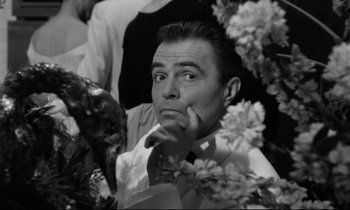 Movie still from “Lolita” (1962), directed by Stanley Kubrick – A black - and - white photo of a man in a suit and tie; Close Up shot, High angle