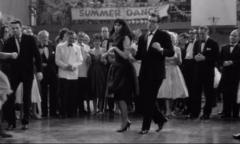 Movie still from “Lolita” (1962), directed by Stanley Kubrick – A man and a woman dancing in front of a crowd; Wide shot, Low angle