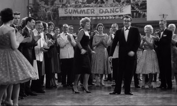 Movie still from “Lolita” (1962), directed by Stanley Kubrick – Black and white photograph of people dancing in front of a crowd; Wide shot, Low angle