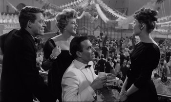 Movie still from “Lolita” (1962), directed by Stanley Kubrick – A group of people in a crowd at a party; Medium shot, High angle