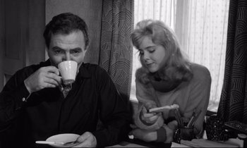 Movie still from “Lolita” (1962), directed by Stanley Kubrick – A man and a woman sitting at a table drinking coffee; Medium shot, High angle
