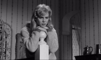 Movie still from “Lolita” (1962), directed by Stanley Kubrick – A woman leaning on a post in a room; Medium shot, High angle