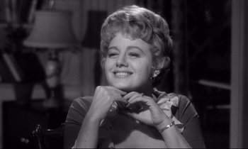 Movie still from “Lolita” (1962), directed by Stanley Kubrick – An old photo of an older woman smiling for the camera; Close Up shot, Over the shoulder angle