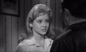 Movie still from “Lolita” (1962), directed by Stanley Kubrick – A young woman in a checkered shirt is talking to a man; Close Up shot, Over the shoulder angle