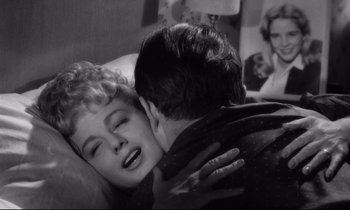 Movie still from “Lolita” (1962), directed by Stanley Kubrick – A man and a woman are kissing in a bed; Close Up shot, Over the shoulder angle