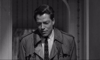 Movie still from “Lolita” (1962), directed by Stanley Kubrick – Black and white photograph of a man wearing a trench coat; Close Up shot, High angle