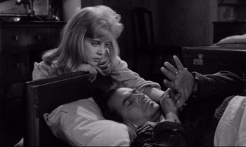 Movie still from “Lolita” (1962), directed by Stanley Kubrick – A man and a woman laying on a bed together; Medium shot, High angle