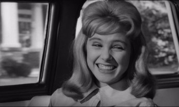 Movie still from “Lolita” (1962), directed by Stanley Kubrick – A black and white photo of a woman smiling; Close Up shot, Over the shoulder angle