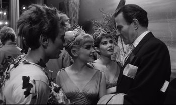 Movie still from “Lolita” (1962), directed by Stanley Kubrick – A group of people standing next to each other in a room; Medium shot, Over the shoulder angle