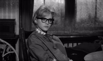 Movie still from “Lolita” (1962), directed by Stanley Kubrick – A woman sitting in a chair wearing glasses; Close Up shot, Low angle