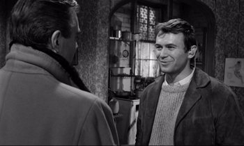 Movie still from “Lolita” (1962), directed by Stanley Kubrick – A man standing next to another man in a room; Medium shot, Over the shoulder angle