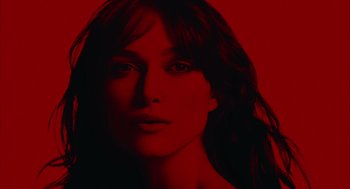 Movie still from “London Boulevard” (2010), directed by William Monahan – A woman with long dark hair is in a red room; Close Up shot, Overhead angle