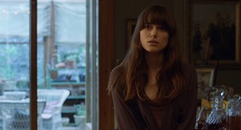 Movie still from “London Boulevard” (2010), directed by William Monahan – A beautiful young woman with long brown hair; Close Up shot, Over the shoulder angle