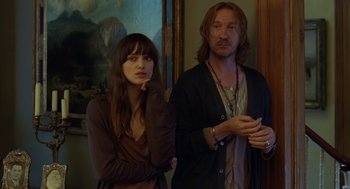 Movie still from “London Boulevard” (2010), directed by William Monahan – A man and a woman standing next to each other in a room; Medium shot, Over the shoulder angle