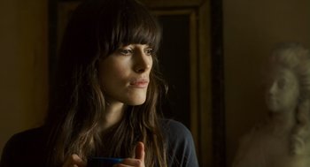 Movie still from “London Boulevard” (2010), directed by William Monahan – A person holding a cup in a room; Close Up shot, Over the shoulder angle