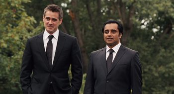 Movie still from “London Boulevard” (2010), directed by William Monahan – A couple of men standing next to each other in suits; Medium shot, Over the shoulder angle