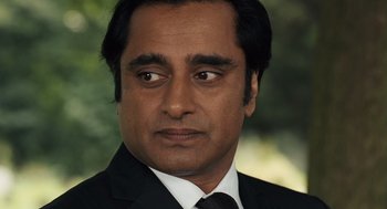 Movie still from “London Boulevard” (2010), directed by William Monahan – A person wearing a suit and tie; Close Up shot, Over the shoulder angle