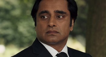 Movie still from “London Boulevard” (2010), directed by William Monahan – A person wearing a suit and tie; Close Up shot, Over the shoulder angle