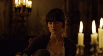 Movie still from “London Boulevard” (2010), directed by William Monahan – A woman sitting in front of a lit candle; Close Up shot, Over the shoulder angle