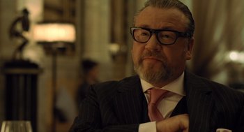 Movie still from “London Boulevard” (2010), directed by William Monahan – An older man in a suit and tie; Close Up shot, Over the shoulder angle
