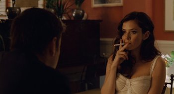 Movie still from “London Boulevard” (2010), directed by William Monahan – A woman smoking a cigarette in front of a young man; Close Up shot, Over the shoulder angle