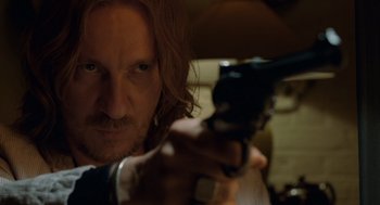 Movie still from “London Boulevard” (2010), directed by William Monahan – A person holding a gun; Close Up shot, Over the shoulder angle