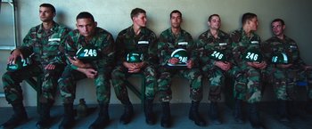 Movie still from “Lone Survivor” (2013), directed by Peter Berg – A group of soldiers sitting in a row holding helmets; Medium shot, High angle