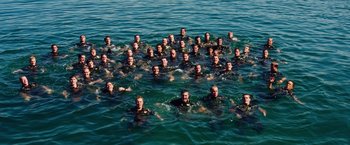Movie still from “Lone Survivor” (2013), directed by Peter Berg – A large group of men in the water; Extreme Wide shot, High angle