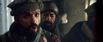 Movie still from “Lone Survivor” (2013), directed by Peter Berg – A man with a beard and a hat and a man with a beard and a hat; Close Up shot, Over the shoulder angle