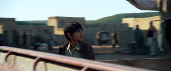 Movie still from “Lone Survivor” (2013), directed by Peter Berg – A young boy looking out the window of a vehicle; Close Up shot, Over the shoulder angle