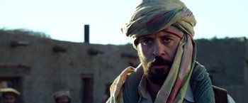 Movie still from “Lone Survivor” (2013), directed by Peter Berg – A man with a beard wearing a turban; Close Up shot, Over the shoulder angle