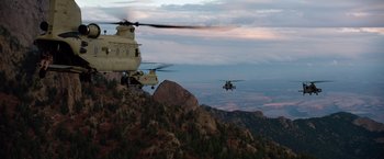 Movie still from “Lone Survivor” (2013), directed by Peter Berg – A helicopter flying over a mountain with another helicopter flying over it; Extreme Wide shot, Low angle