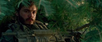 Movie still from “Lone Survivor” (2013), directed by Peter Berg – A man with a beard is sitting on a rifle; Close Up shot, Over the shoulder angle