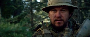 Movie still from “Lone Survivor” (2013), directed by Peter Berg – A person wearing a hat; Close Up shot, Over the shoulder angle