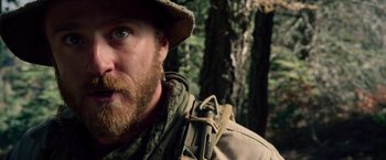 Movie still from “Lone Survivor” (2013), directed by Peter Berg – A person wearing a hat and a backpack; Close Up shot, Over the shoulder angle