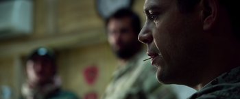 Movie still from “Lone Survivor” (2013), directed by Peter Berg – A person with a stick in his mouth; Close Up shot, Over the shoulder angle