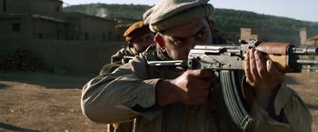 Movie still from “Lone Survivor” (2013), directed by Peter Berg – A man with a gun in his hand and another man with a gun in his other hand; Close Up shot, Low angle