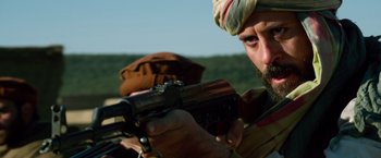 Movie still from “Lone Survivor” (2013), directed by Peter Berg – A person holding a gun; Close Up shot, Low angle